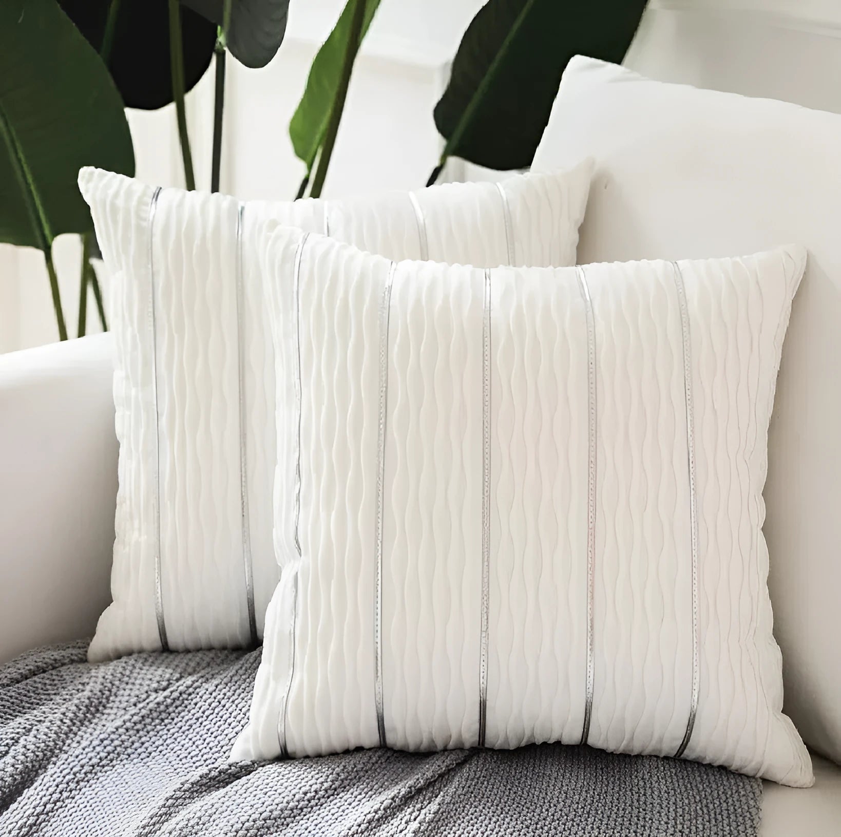 Soft striped velvet pillow cover for a sofa cushion in silver grey colour, shown on a chair.