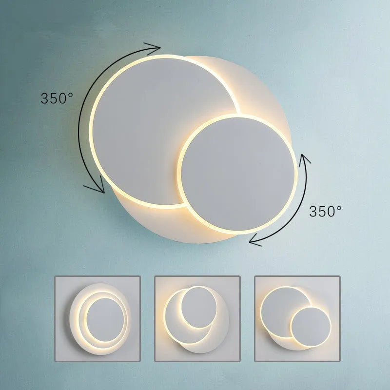 Simple modern round wall lamp with acrylic shade in black or white finish.