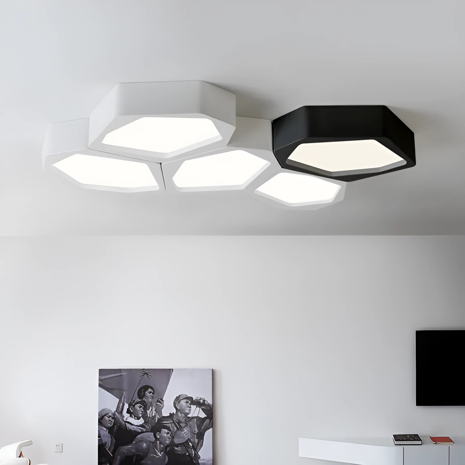 Modern geometric-shaped LED light with black iron frame and remote control on a side table.