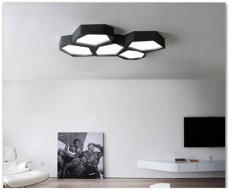 Modern geometric-shaped LED light with black iron frame and remote control on a side table.