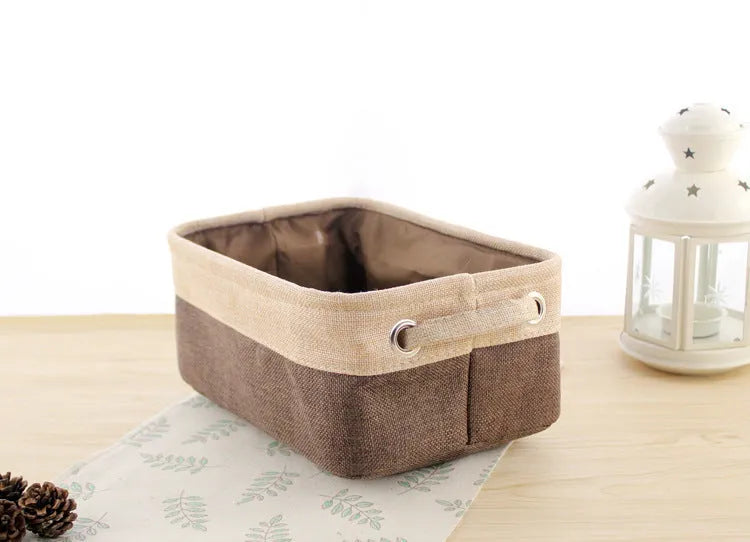 A folded and an unfolded Nordic-style fabric storage box in a neutral colour on a wooden floor.