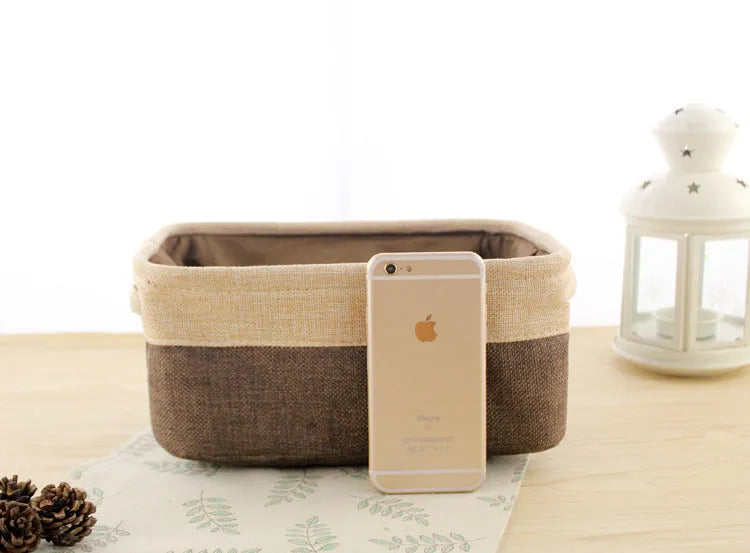 A folded and an unfolded Nordic-style fabric storage box in a neutral colour on a wooden floor.