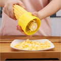 Yellow manual corn grinder thresher with corn-shaped PP handle for removing kernels.