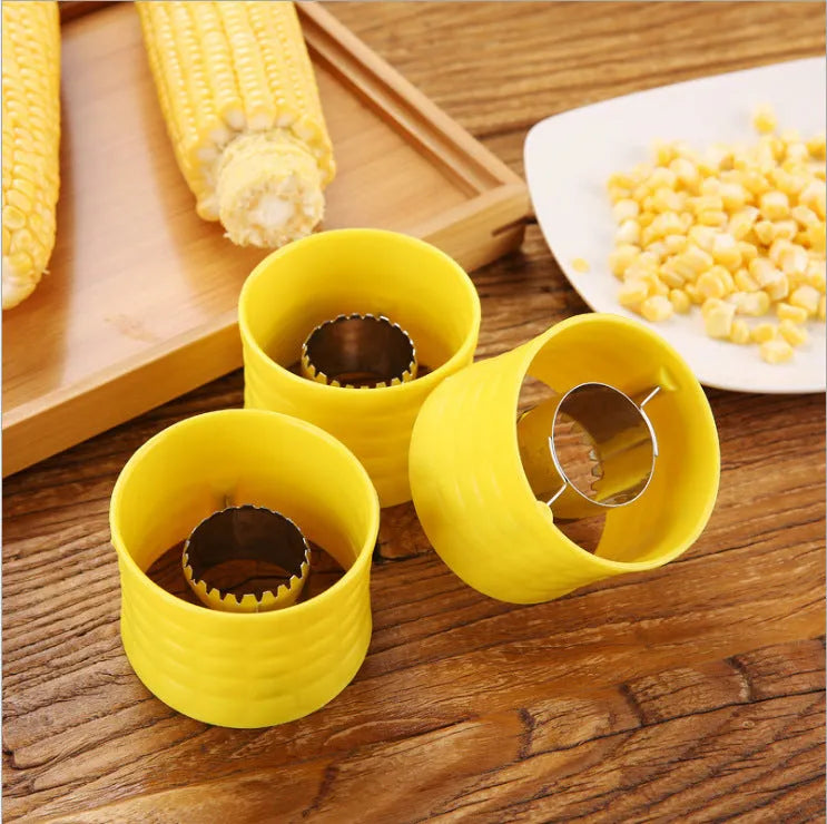 Yellow manual corn grinder thresher with corn-shaped design on a kitchen counter.