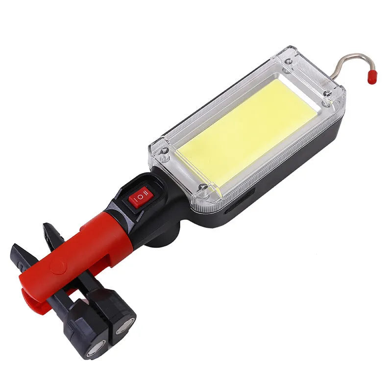 Red portable COB LED work light with magnet base and hook, showing USB charging port.