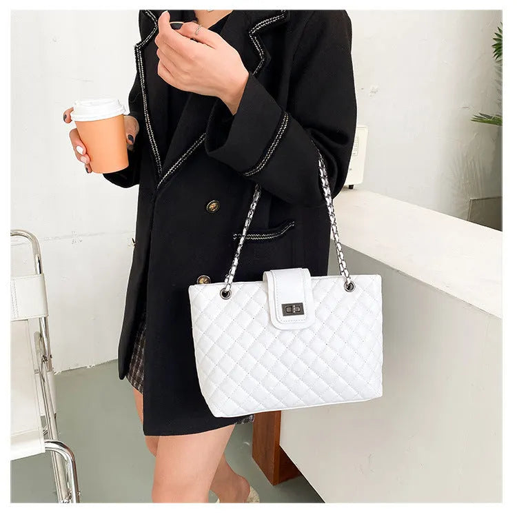 Large women's PU leather tote bag with lock closure and chain shoulder strap in horizontal square shape on white background
