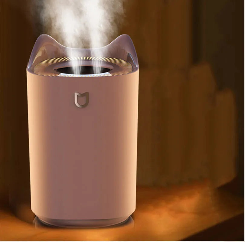 Coral Pink double spray USB humidifier with three mist outlets and a large water tank on a wooden surface.