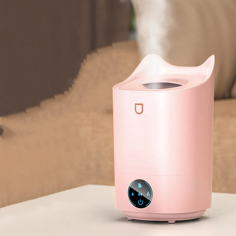 Coral Pink double spray USB humidifier with three mist outlets and a large water tank on a wooden surface.