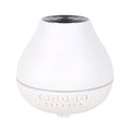 White round Bluetooth aroma diffuser and humidifier with night light on a wooden table