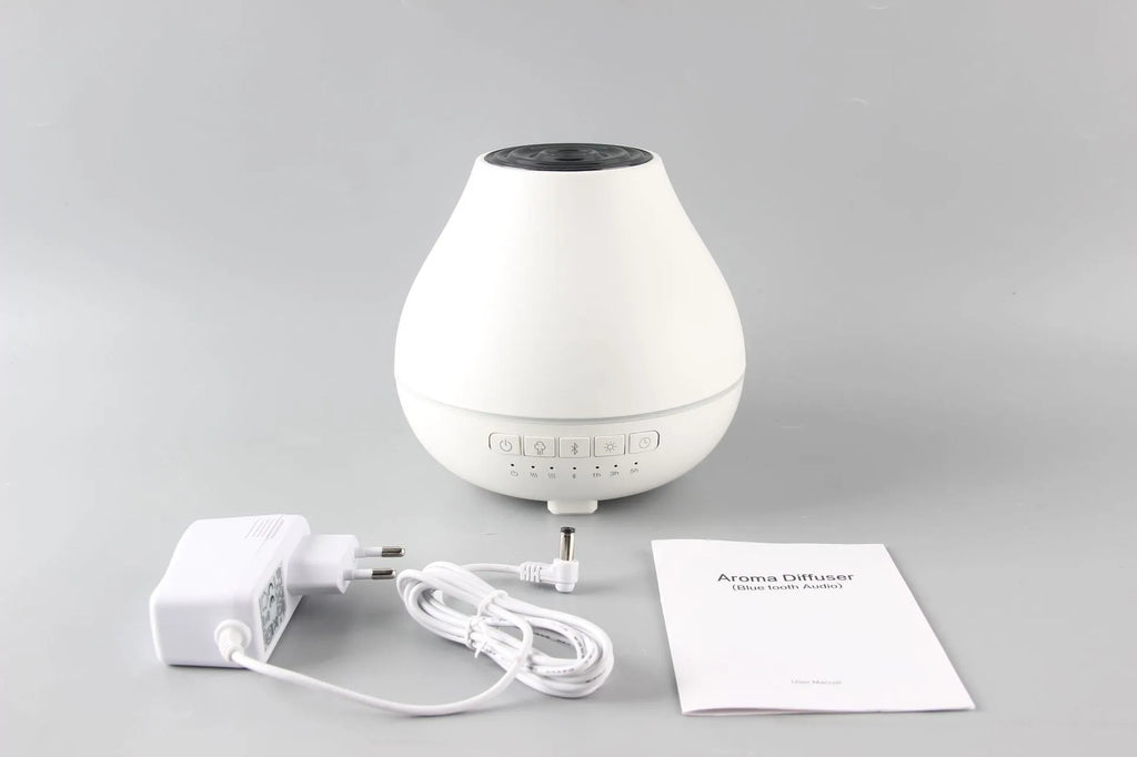 White round Bluetooth aroma diffuser and humidifier with night light on a wooden table