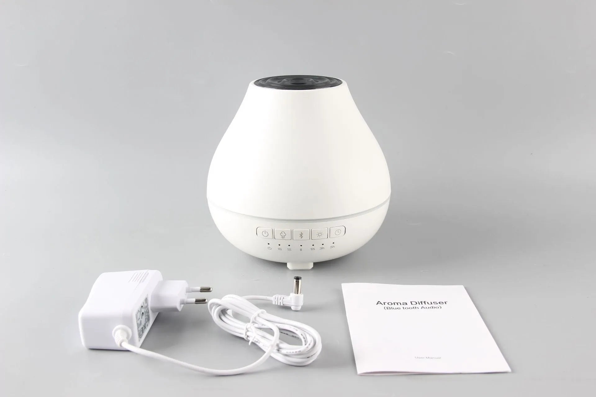 White round Bluetooth aroma diffuser and humidifier with night light on a wooden table