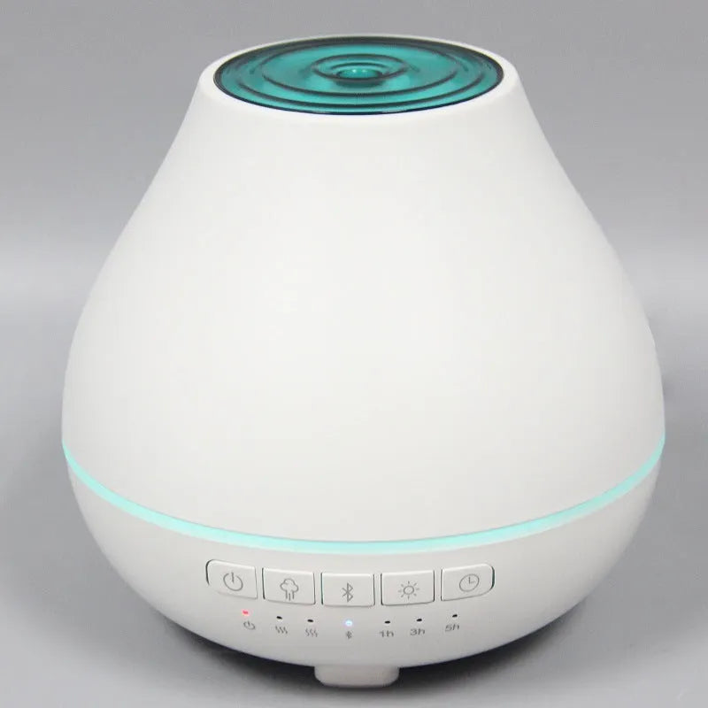 White round Bluetooth aroma diffuser and humidifier with night light on a wooden table