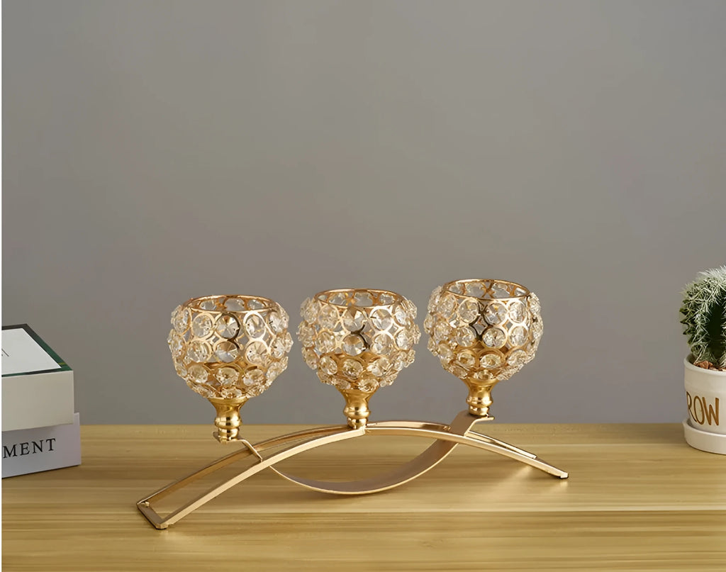 Gold crystal candle holder with geometric wrought iron frame on a table surface