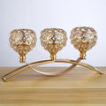 Gold crystal candle holder with geometric wrought iron frame on a table surface