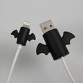 White and black silicone cable protective covers shown next to a charging cable.