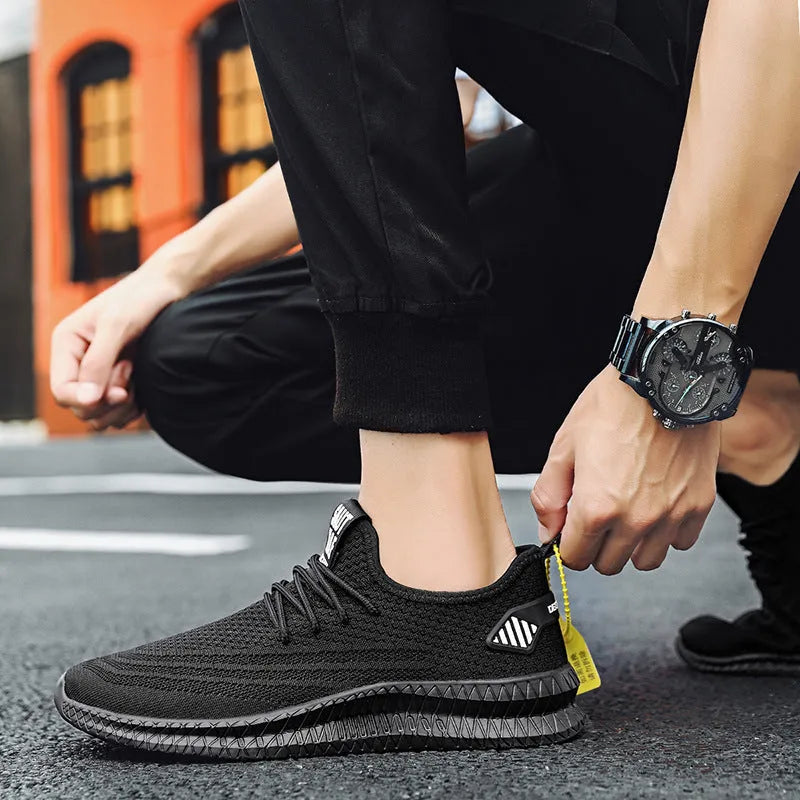 Men's mesh running shoes in black with flying weave upper and white EVA sole on grey background