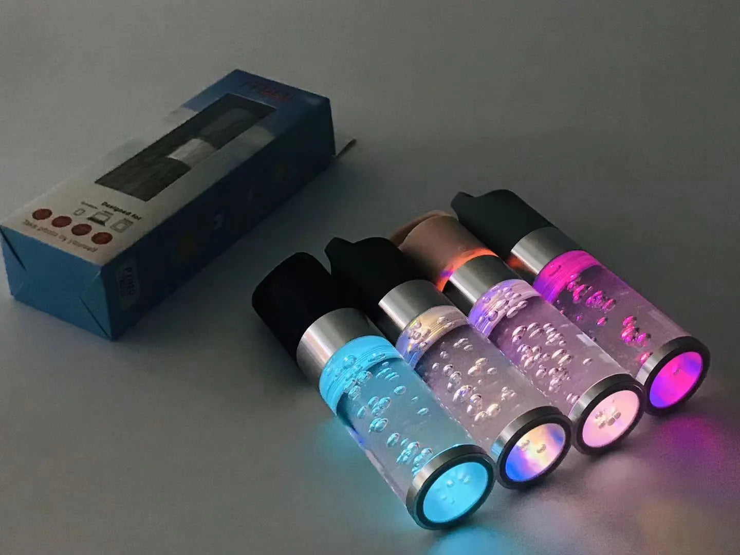 Pink portable Bluetooth speaker with illuminated crystal light panel on front, showing compact size.