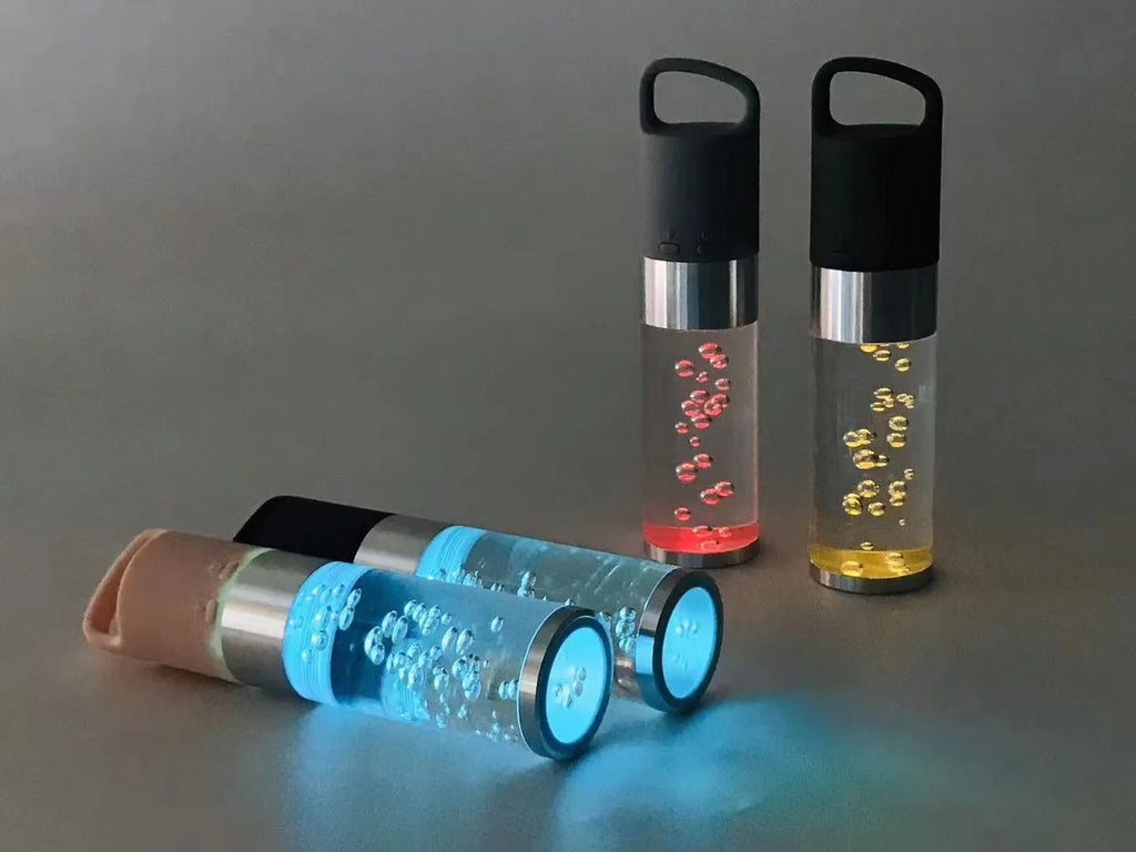Pink portable Bluetooth speaker with illuminated crystal light panel on front, showing compact size.