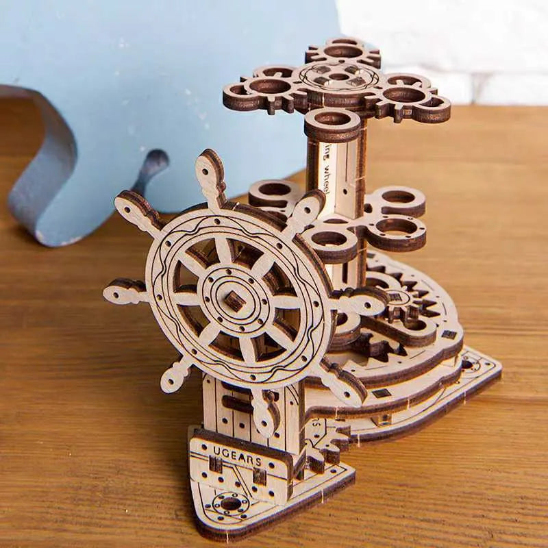 Ukrainian wooden desk pen holder with a rotating steering wheel mechanism, holding coloured pencils.