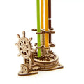 Ukrainian wooden desk pen holder with a rotating steering wheel mechanism, holding coloured pencils.