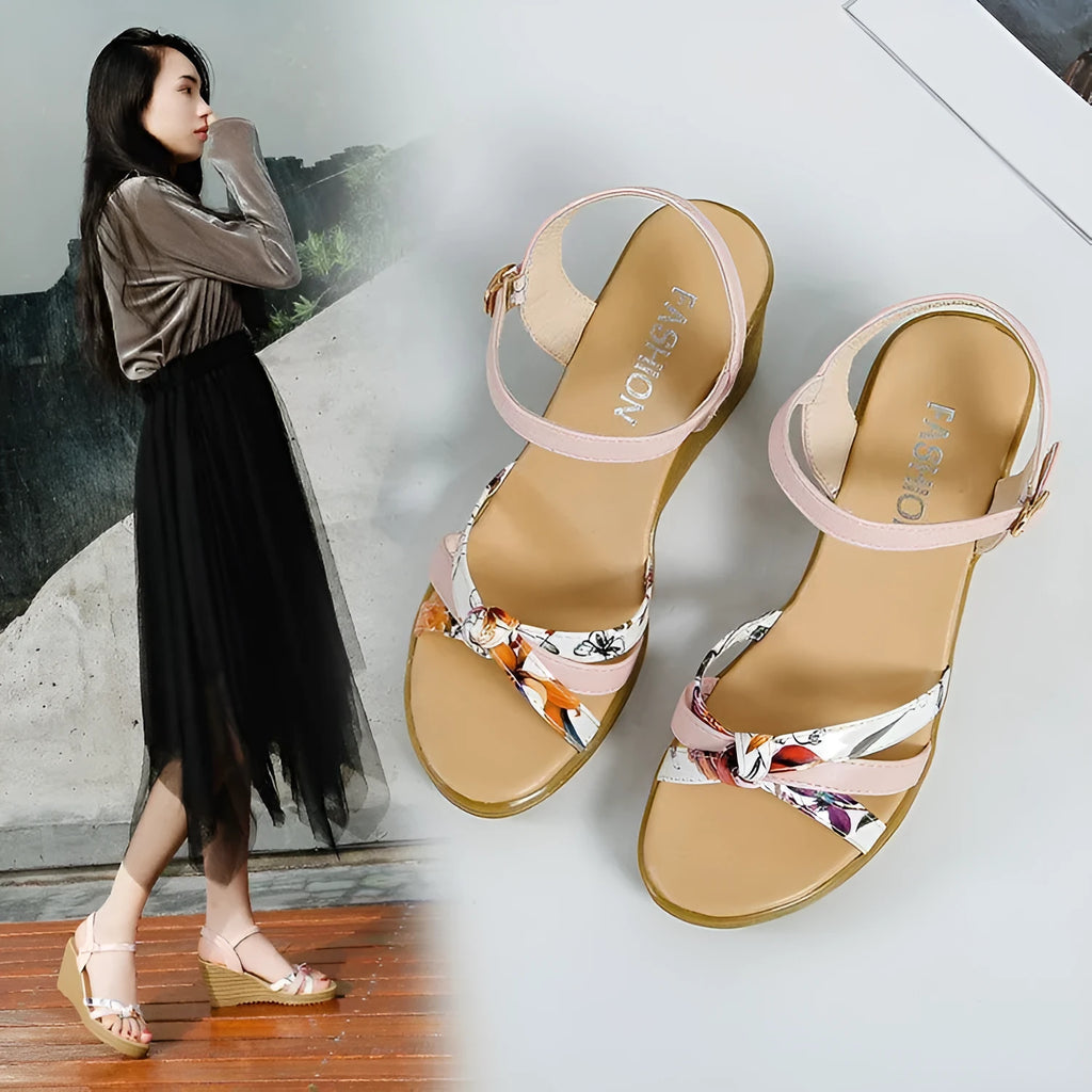 Women's pink wedge heel sandals with a single adjustable buckle strap on a white background.