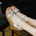 Women's pink wedge heel sandals with a single adjustable buckle strap on a white background.