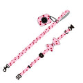 Pink cloth dog leash set with chest strap, collar, and rope on a surface