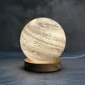 Girl Heart Nordic style USB table lamp with a glass shade in a choice of seven colours on a wooden bedside table.