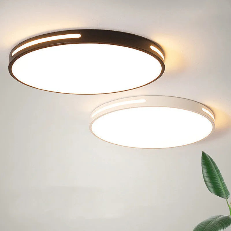Round modern acrylic ceiling lamp with remote control in white light on a room ceiling.