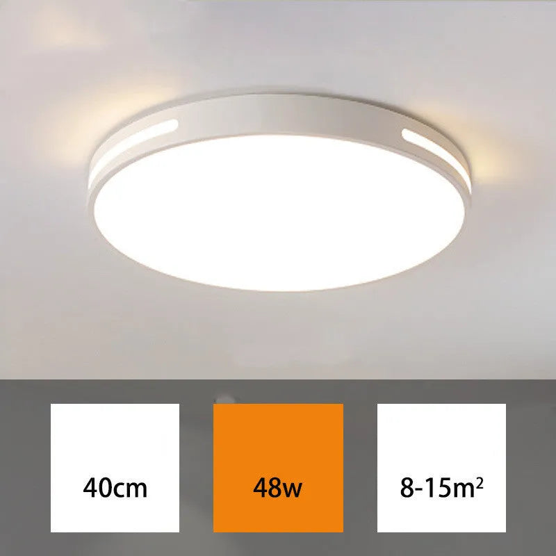 Round modern acrylic ceiling lamp with remote control in white light on a room ceiling.