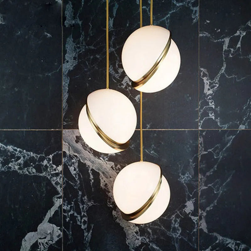 Nordic pendant light with white spherical glass lampshade and golden accents on adjustable cord