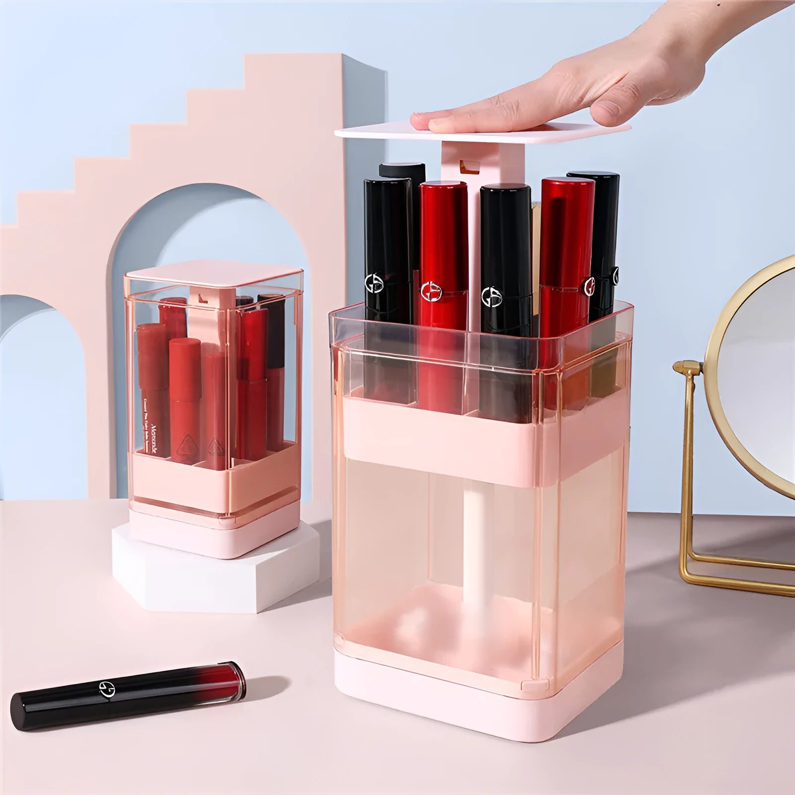 White press-lift lipstick storage box with dust cover on a desktop, showing multiple compartments.
