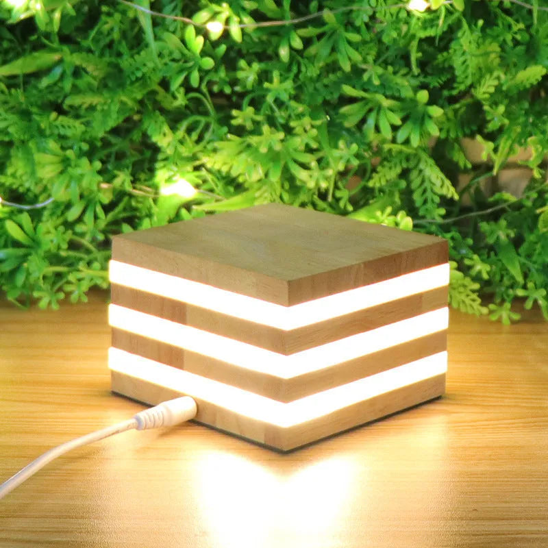 Solid wood square LED night light with warm white light on a wooden bedside table