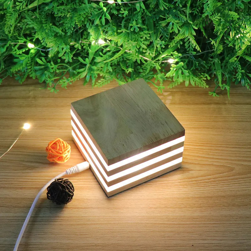Solid wood square LED night light with warm white light on a wooden bedside table