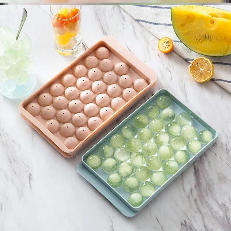 Round ball ice cube moulds in sky blue and pink creating spherical ice for drinks