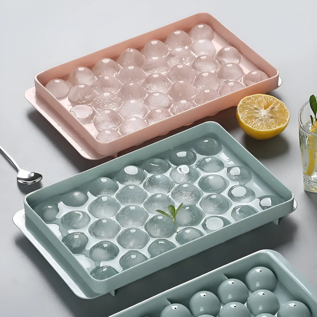 Round ball ice cube moulds in sky blue and pink creating spherical ice for drinks