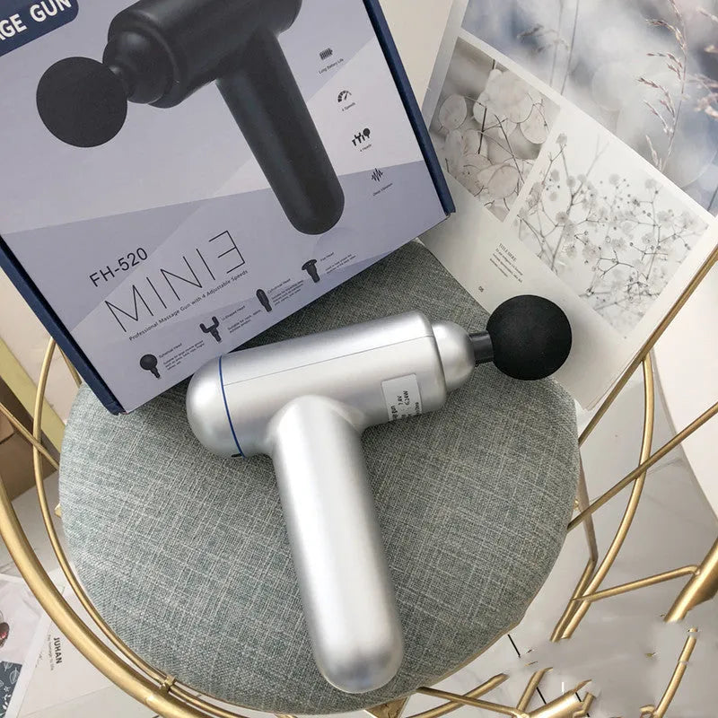 Black, red, and grey coloured handheld fascia massage gun with USB charging port.