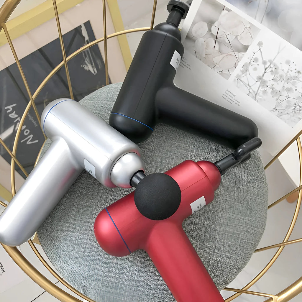 Black, red, and grey coloured handheld fascia massage gun with USB charging port.