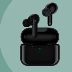 Black and white wireless in-ear Bluetooth headphones with a magnetic charging case on a table.