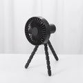 Small black adjustable tripod desktop fan with bending neck and clip, shown on a desk.