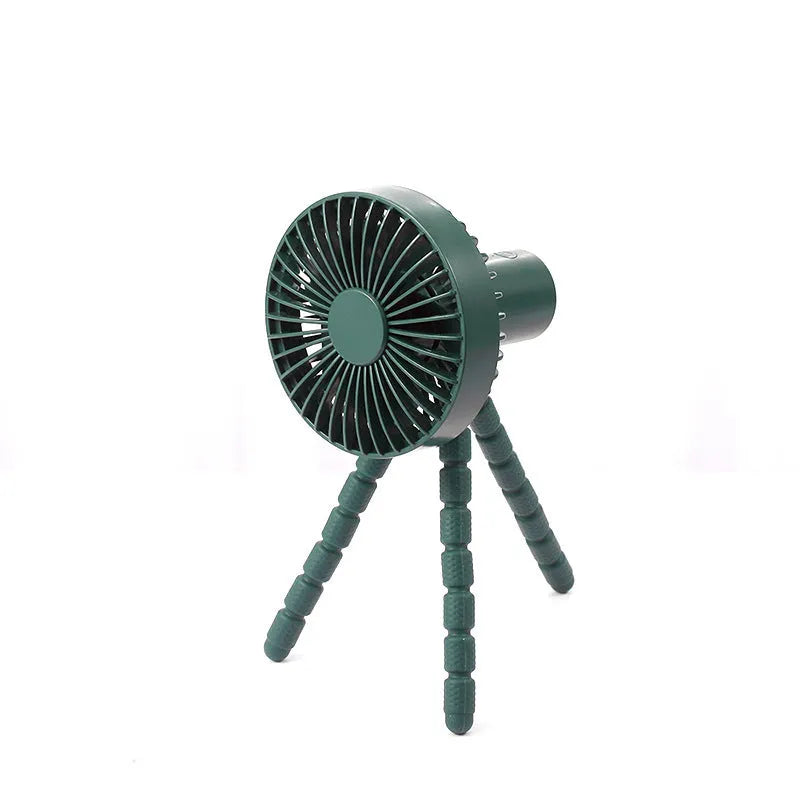 Small black adjustable tripod desktop fan with bending neck and clip, shown on a desk.