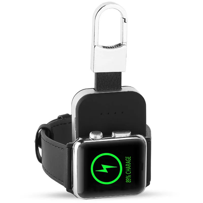 Black Apple Watch keychain power bank with wireless charging pad next to an Apple Watch.