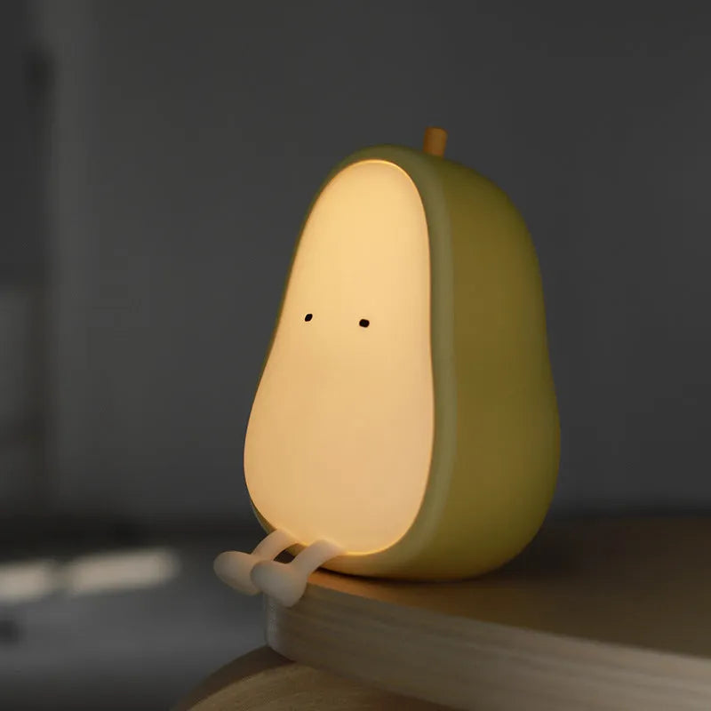 Yali pear-shaped silicone night light emitting warm yellow light on a bedside table.