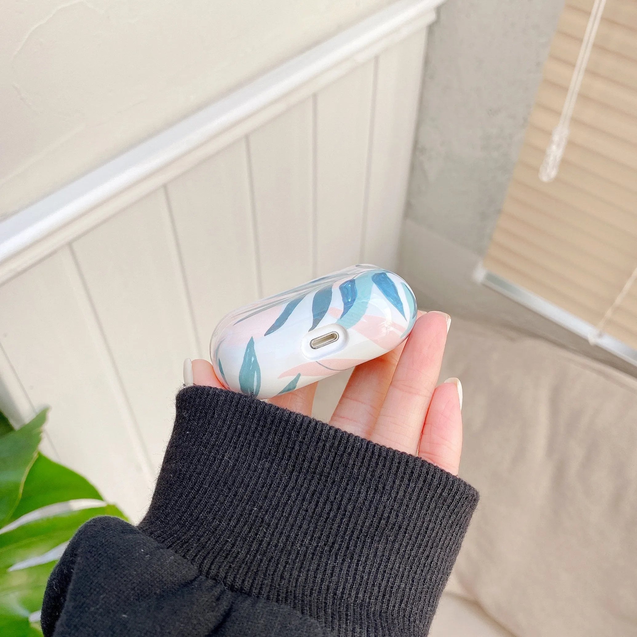 Blue and green tropical banana leaf patterned soft TPU case for Apple AirPods.