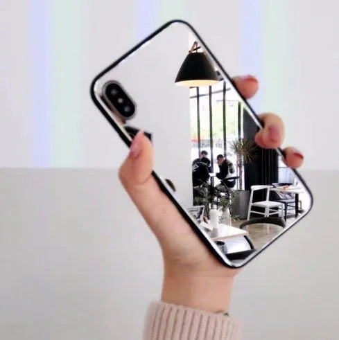 Black iPhone case with a reflective mirror panel on the back, shown fitted to an iPhone.