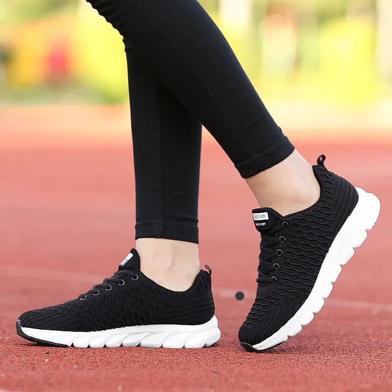 Women's running shoes in black, pink, or white with a fly weaving upper and wear-resistant outsole.