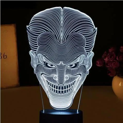 Compact USB-powered 3D LED desk lamp with a touch switch and remote control on a desk.