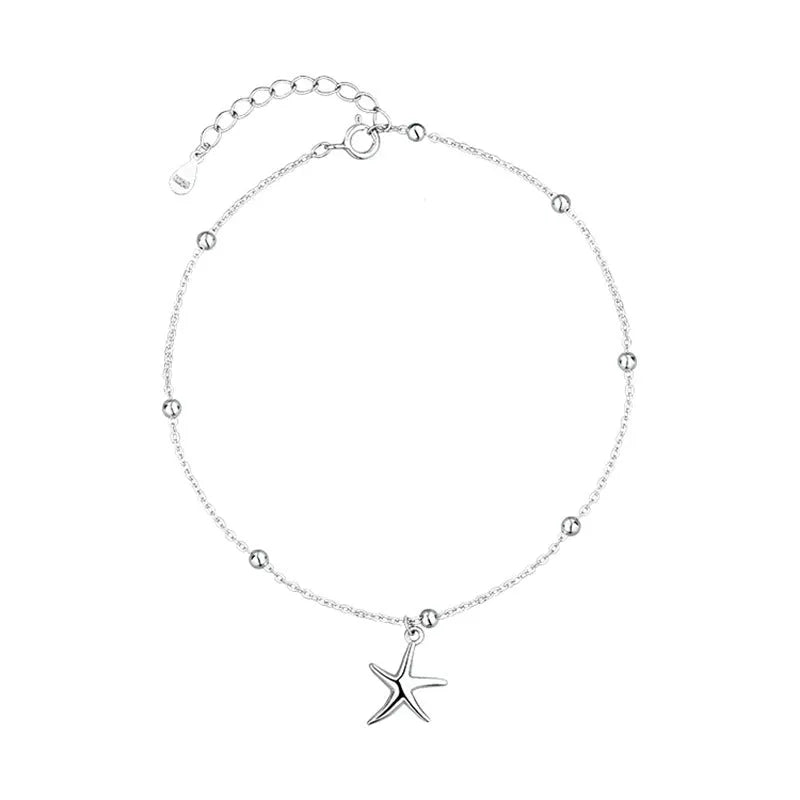 Adjustable sterling silver anklet with round beads and a detailed starfish charm on an ankle.