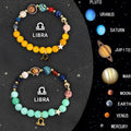 Two natural stone bead bracelets with zodiac charms on a wooden surface, showing adjustable metal slide fastenings.