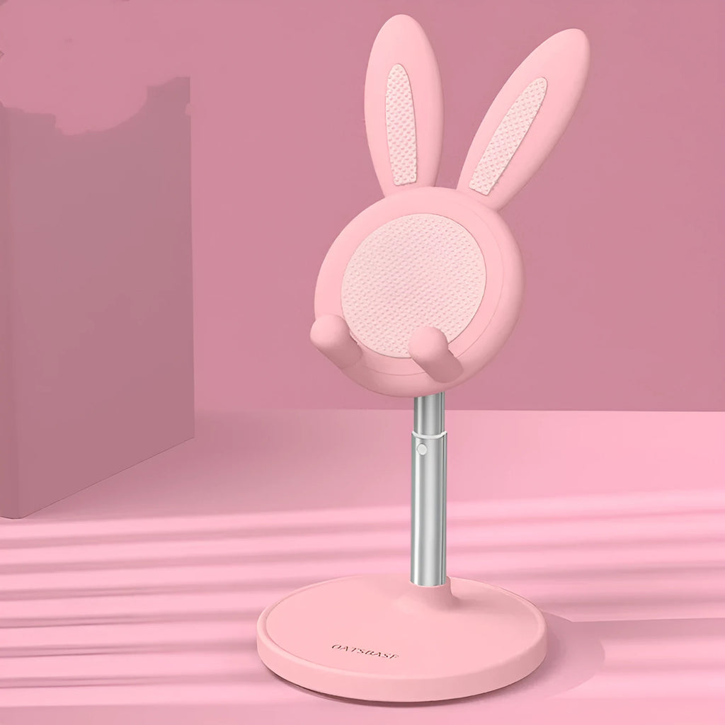 Rabbit-shaped silicone phone stand in pink on a desk with a mobile phone